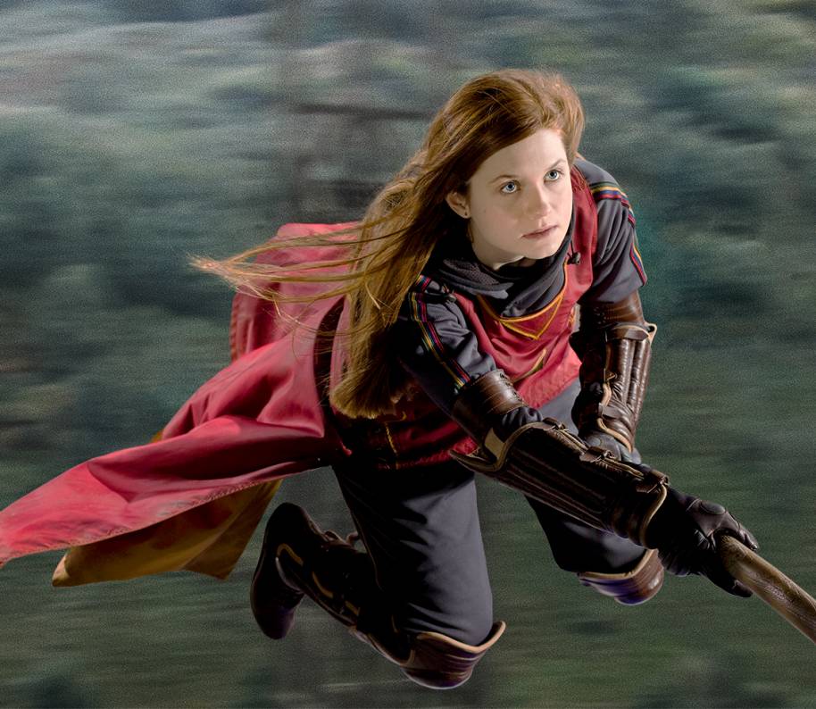 Ginny is wearing Gryffindor Quidditch robes and flying on her broomstick.